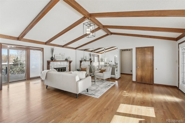 living room with vaulted ceiling with beams, light hardwood / wood-style flooring, and a high end fireplace