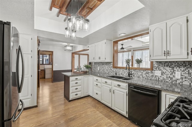 kitchen featuring dishwasher, white cabinetry, stainless steel refrigerator, and washer / clothes dryer