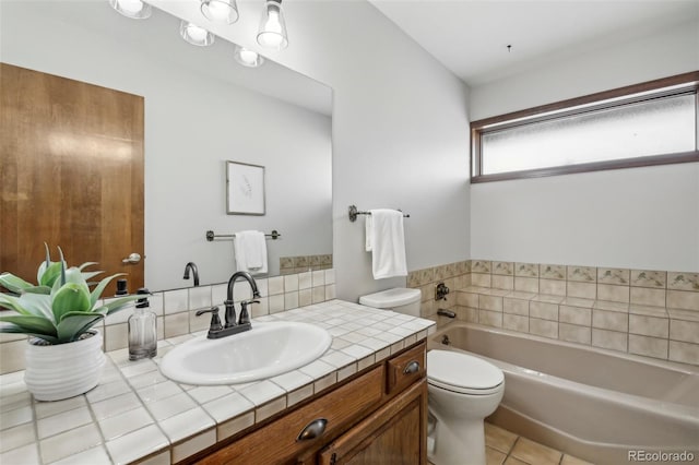 bathroom featuring tile patterned flooring, a bath, vanity, and toilet