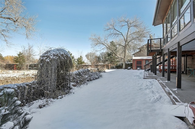 yard layered in snow with a storage unit