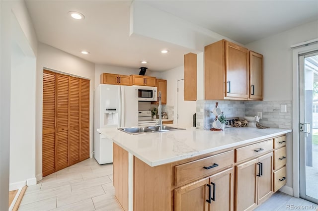 1060 Grove St, Denver, CO 80204 - kitchen featuring white appliances, decorative backsplash, light countertops, a peninsula, and recessed lighting
