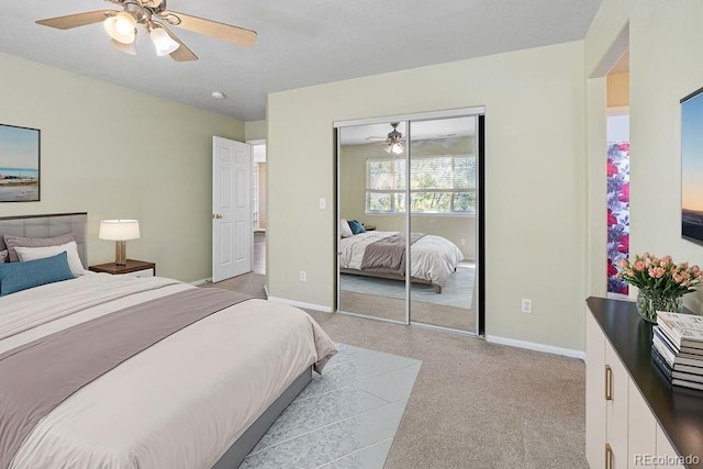 bedroom with ceiling fan, a closet, and light colored carpet