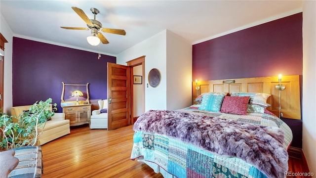 bedroom featuring ceiling fan, wood-type flooring, and ornamental molding