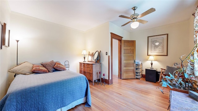 bedroom with ceiling fan, light hardwood / wood-style floors, and ornamental molding