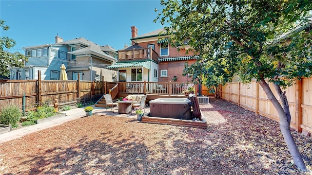 rear view of house featuring a balcony, a hot tub, and cooling unit