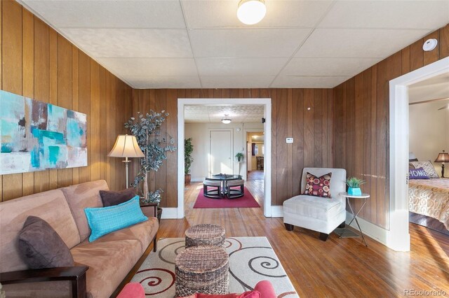 living room with hardwood / wood-style flooring and wood walls