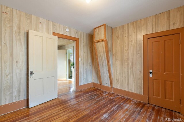 spare room with wood walls and dark hardwood / wood-style floors