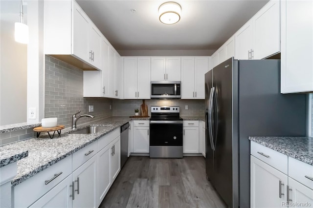 15700 E Jamison Dr Unit 305, Englewood, CO 80112 - kitchen with stainless steel appliances, wood finished floors, light stone countertops, and white cabinetry