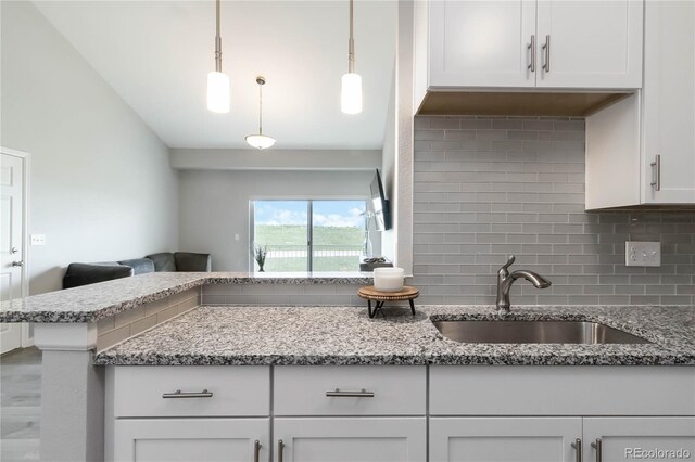 15700 E Jamison Dr Unit 305, Englewood, CO 80112 - kitchen with decorative backsplash, white cabinetry, light stone countertops, and pendant lighting