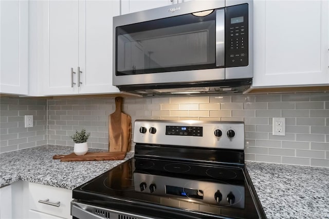 15700 E Jamison Dr Unit 305, Englewood, CO 80112 - kitchen with stainless steel appliances, tasteful backsplash, white cabinets, and light stone countertops