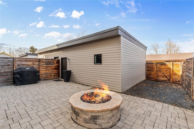 exterior space with a gate, a grill, a fire pit, and fence