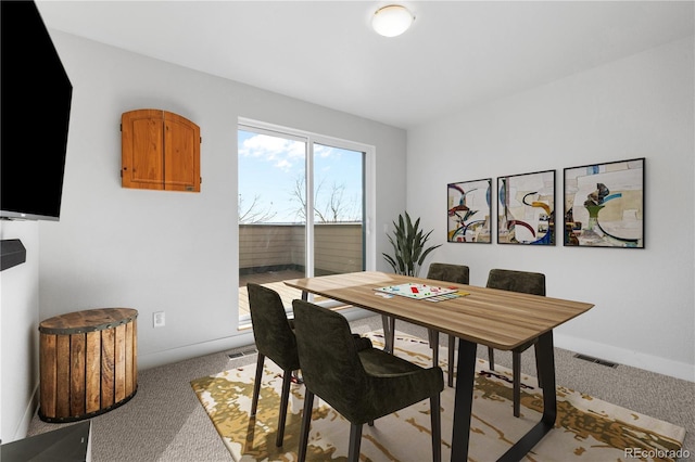 dining room with carpet floors, visible vents, and baseboards