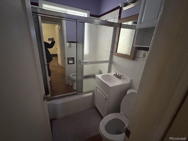 full bathroom with toilet, enclosed tub / shower combo, and vanity