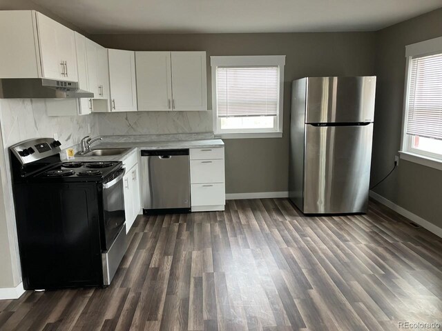 kitchen featuring white cabinetry, sink, dark wood-type flooring, backsplash, and appliances with stainless steel finishes