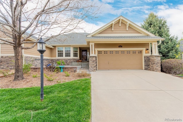craftsman-style house with stone siding, driveway, an attached garage, and a shingled roof