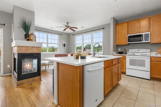 7130 Simms St Unit 206, Arvada, CO 80004 - kitchen with white appliances, a sink, light countertops, and a multi sided fireplace