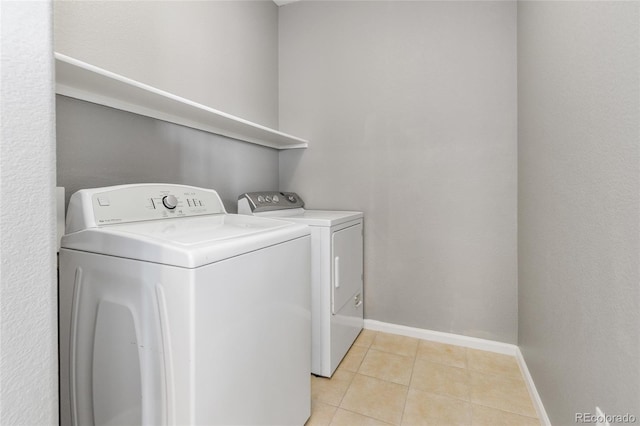 7130 Simms St Unit 206, Arvada, CO 80004 - laundry room featuring washing machine and clothes dryer, light tile patterned floors, and baseboards