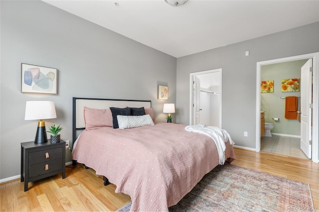 7130 Simms St Unit 206, Arvada, CO 80004 - bedroom featuring wood finished floors, a spacious closet, baseboards, and ensuite bathroom
