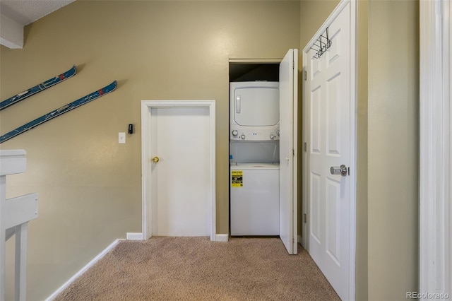 washroom with stacked washing maching and dryer, light carpet, laundry area, and baseboards