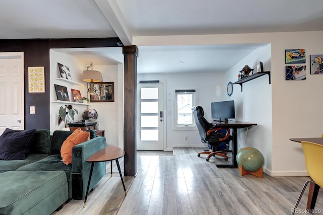 living room featuring ornate columns, hardwood / wood-style flooring, and beam ceiling