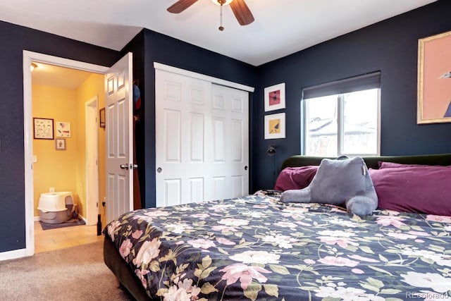 carpeted bedroom with ceiling fan and a closet