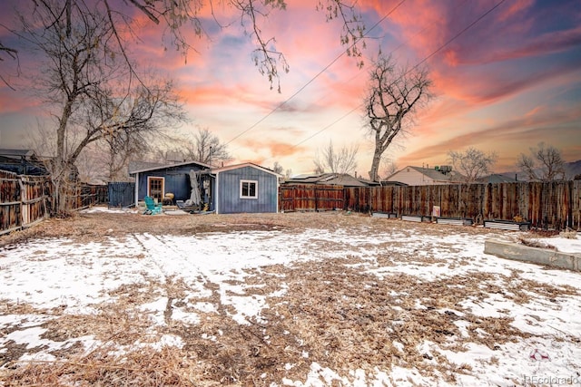 yard covered in snow featuring a storage unit