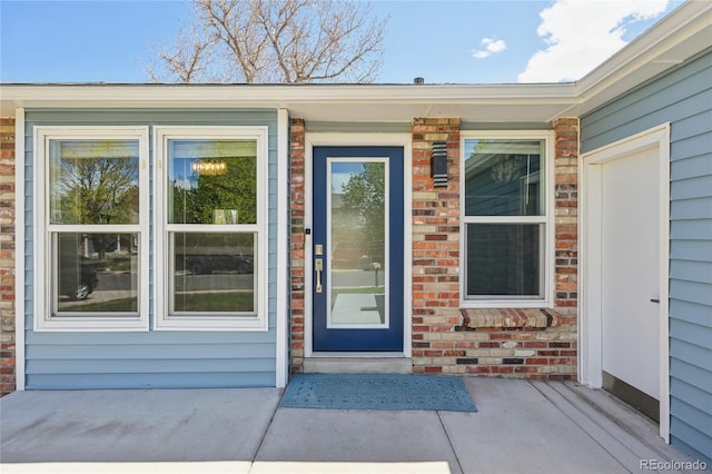 doorway to property featuring brick siding