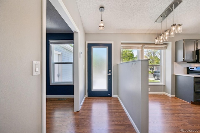 entryway featuring dark wood-type flooring, a textured ceiling, and visible vents