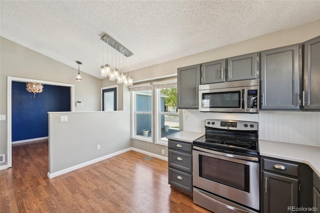 kitchen featuring light countertops, appliances with stainless steel finishes, a textured ceiling, and a notable chandelier