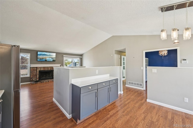 kitchen with gray cabinets, freestanding refrigerator, wood finished floors, and open floor plan