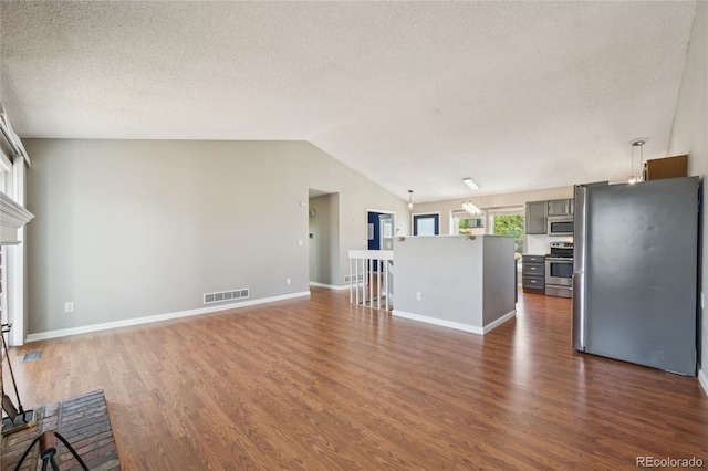 unfurnished living room featuring lofted ceiling, dark wood finished floors, a textured ceiling, and visible vents
