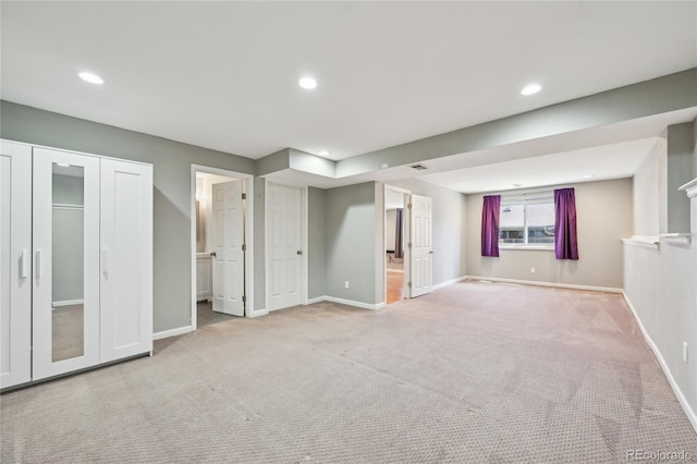 interior space featuring baseboards, ensuite bathroom, and carpet