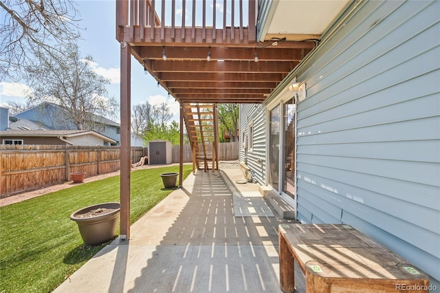 view of patio / terrace with a fenced backyard, an outbuilding, and a shed