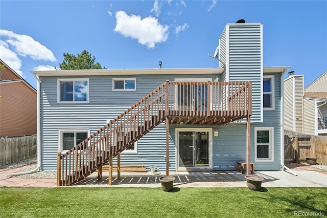 rear view of property with fence, a lawn, and a patio area