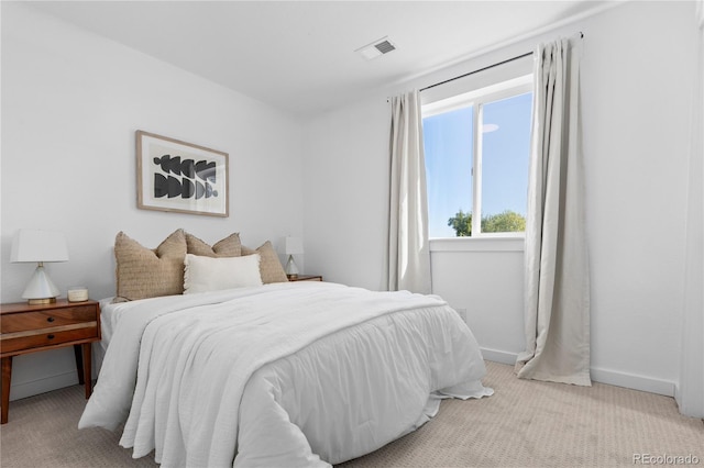 bedroom featuring light carpet, visible vents, and baseboards