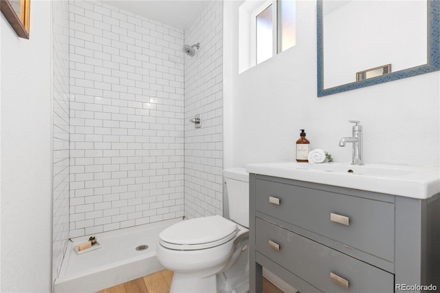 bathroom featuring toilet, a stall shower, and vanity