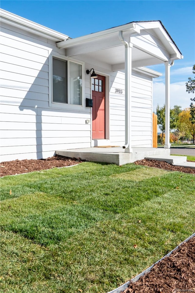 view of exterior entry with a yard