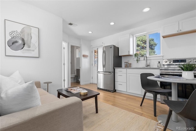 living room with sink and light hardwood / wood-style flooring