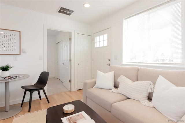 living area with baseboards, light wood finished floors, visible vents, and recessed lighting