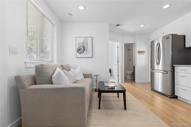 living room featuring recessed lighting, visible vents, light wood-style flooring, and baseboards