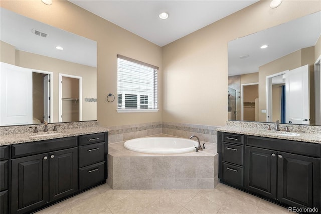 10122 Des Moines St, Parker, CO 80134 - full bath with two vanities, tile patterned floors, a bath, a shower stall, and a walk in closet
