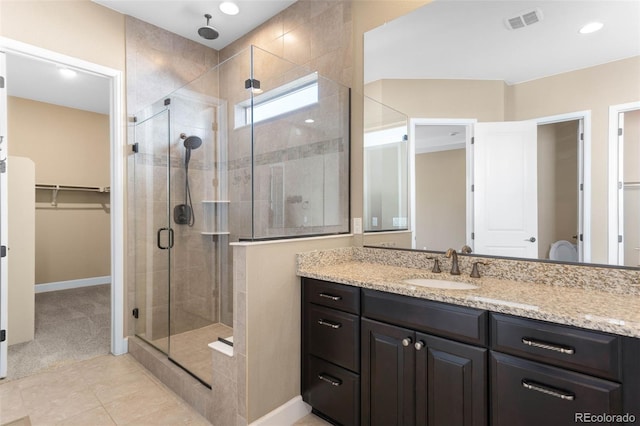 10122 Des Moines St, Parker, CO 80134 - bathroom featuring a shower stall, vanity, a walk in closet, tile patterned floors, and recessed lighting