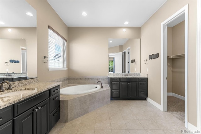 10122 Des Moines St, Parker, CO 80134 - full bath featuring two vanities, a garden tub, healthy amount of natural light, tile patterned flooring, and recessed lighting