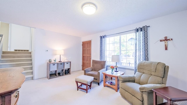 sitting room featuring light colored carpet and a textured ceiling