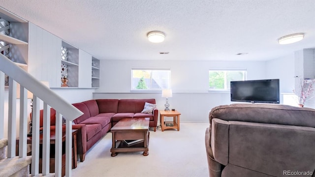 carpeted living room featuring a textured ceiling