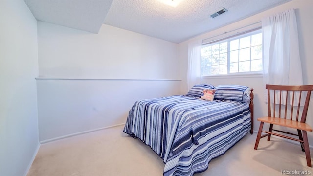 bedroom featuring carpet floors and a textured ceiling