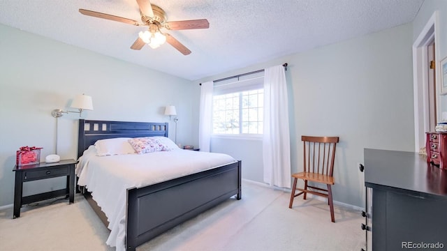 bedroom featuring a textured ceiling, ceiling fan, and light carpet