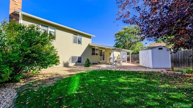 rear view of house featuring a lawn, a patio area, and a shed