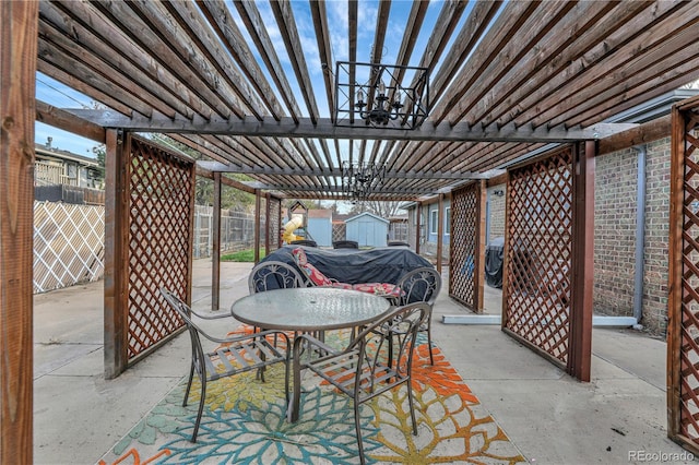 view of patio / terrace with a pergola and a shed