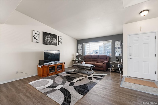 living area featuring vaulted ceiling, wood finished floors, and baseboards